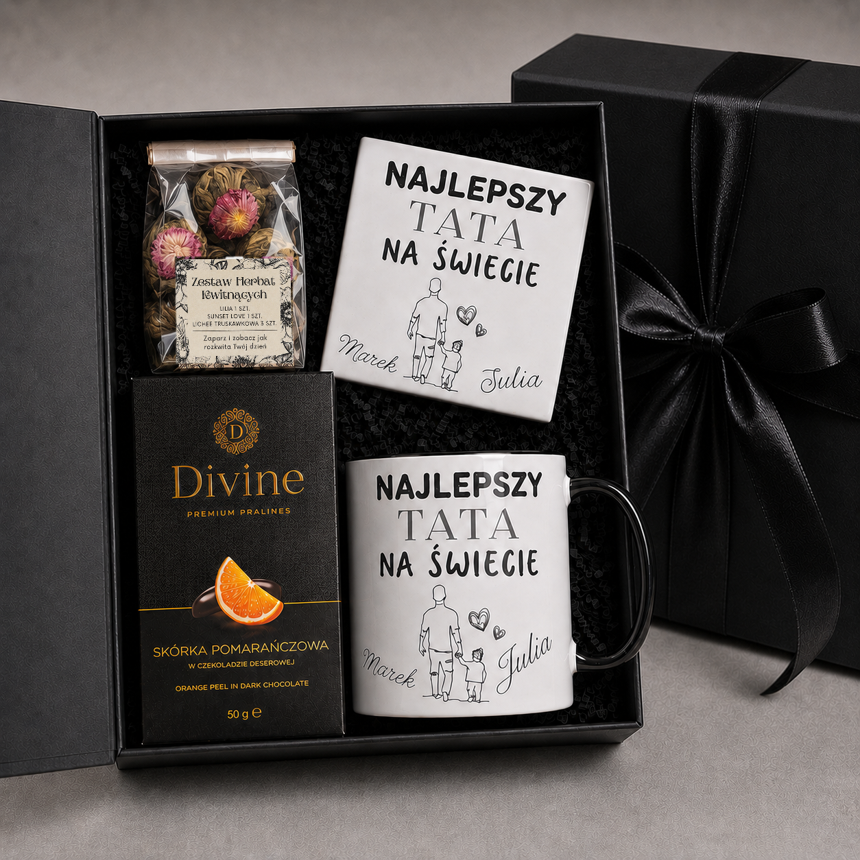 Czarny box prezentowy z personalizowanym kubkiem, podkładką, herbatami kwitnącymi i skórką pomarańczową w czekoladzie